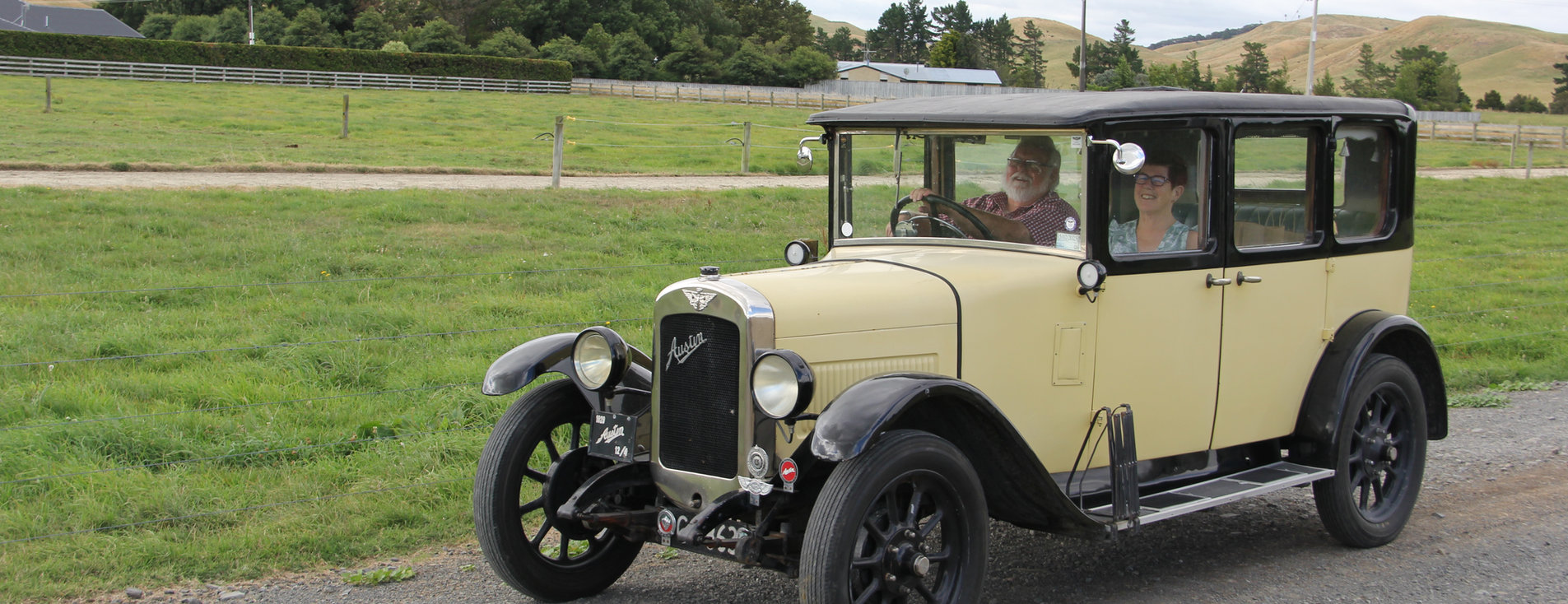 Ewan Cameron, Hawkes Bay Branch Organiser, and his wife Kate smiling in their yellow Austin 12/4